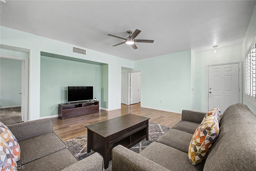 2153 Quarry Ridge Street, Unit 103 Las Vegas, NV 89117 - Photo 15 of 42 Laminated flooring and a ceiling fan enhance this cozy living space, perfect for relaxing.