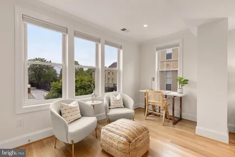 a living room with furniture and a painting on the wall