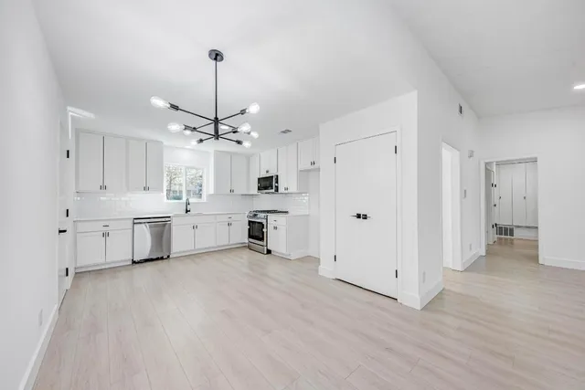 a view of a kitchen with white cabinets and white appliances