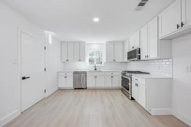 a kitchen with white cabinets and white appliances
