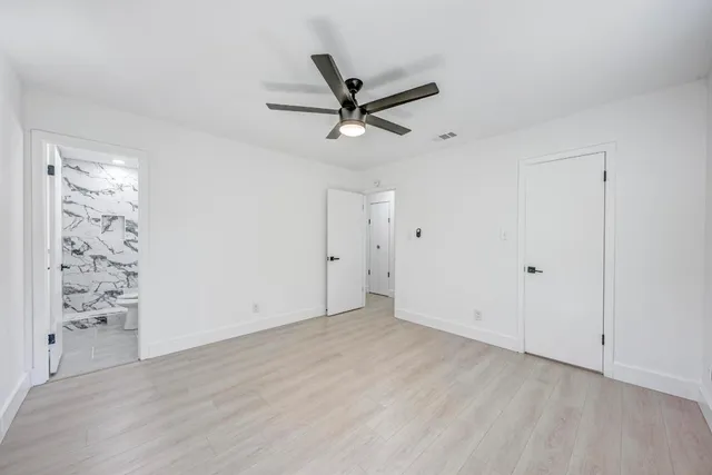 an empty room with window and ceiling fan