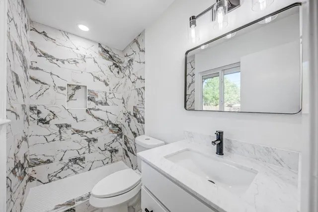 a bathroom with a toilet sink and mirror