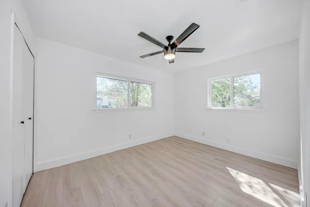 a view of empty room with wooden floor and window