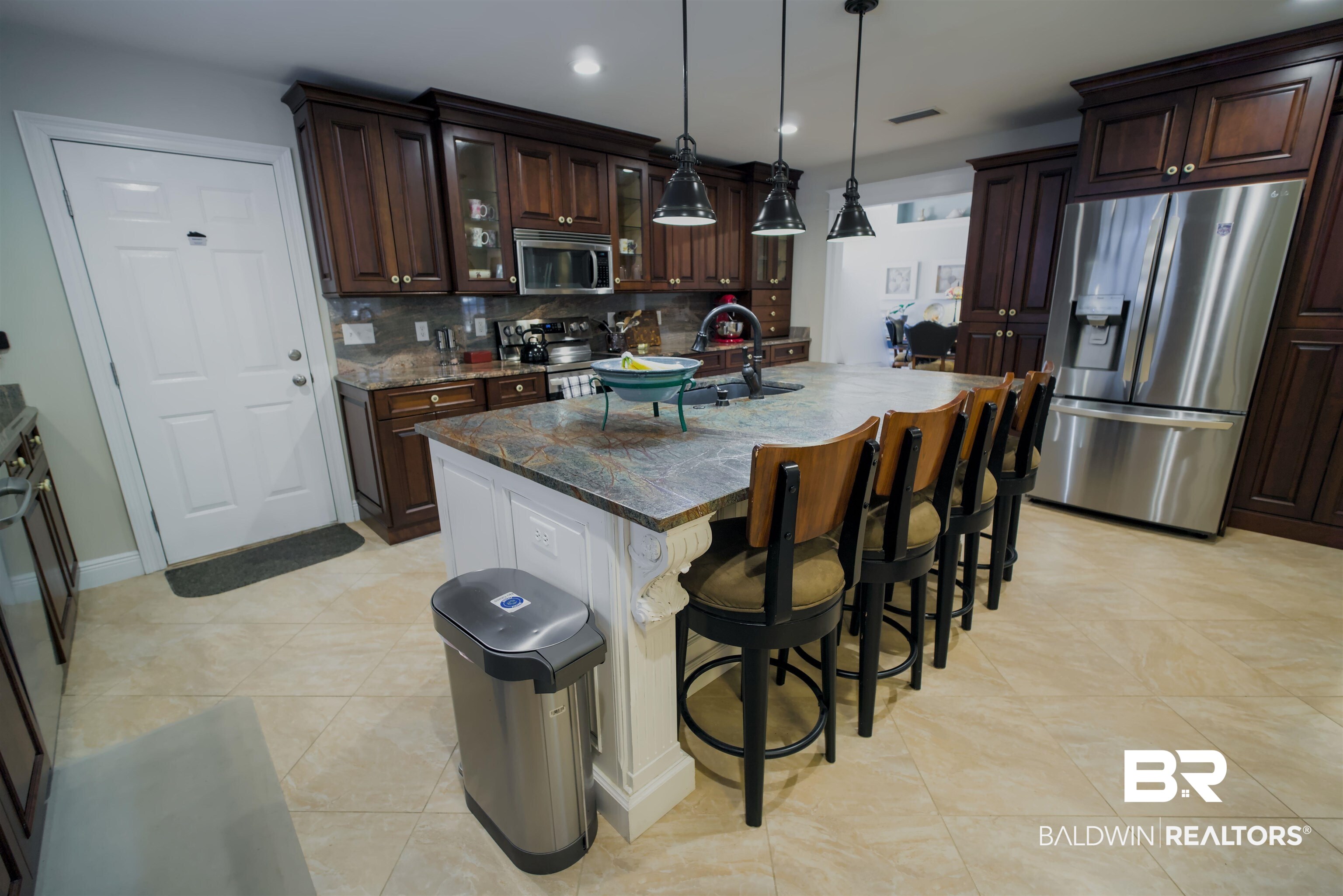373 Collinwood Loop Foley, AL 36535 - Photo 13 of 49 Kitchen featuring a large island with seating, dark wood cabinetry, stainless steel appliances, pendant lighting, and tile flooring
