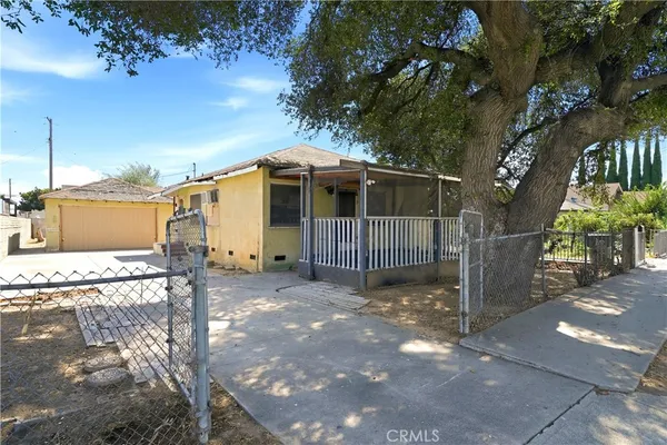 a view of a small house with a tree in the yard
