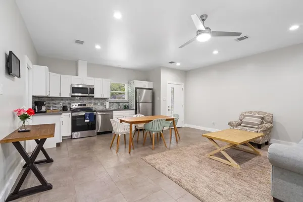 a living room with furniture a dining table and kitchen view