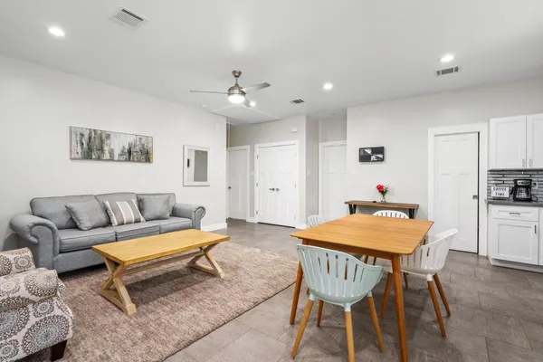 a living room with furniture a kitchen view and a refrigerator