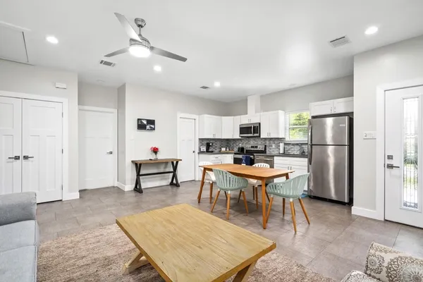 a kitchen with a refrigerator a stove a dining table and chairs
