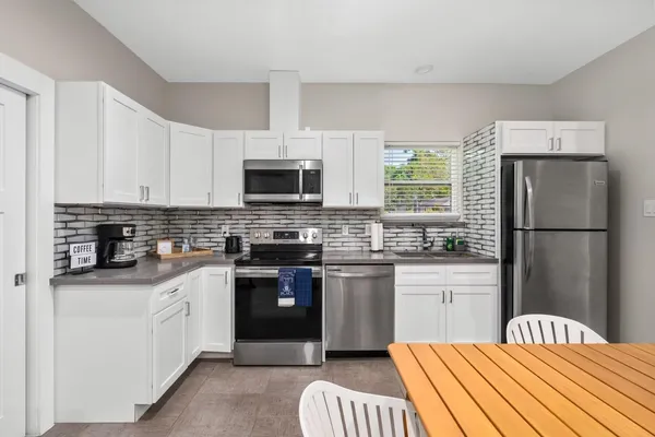 a kitchen with stainless steel appliances a stove sink microwave and cabinets
