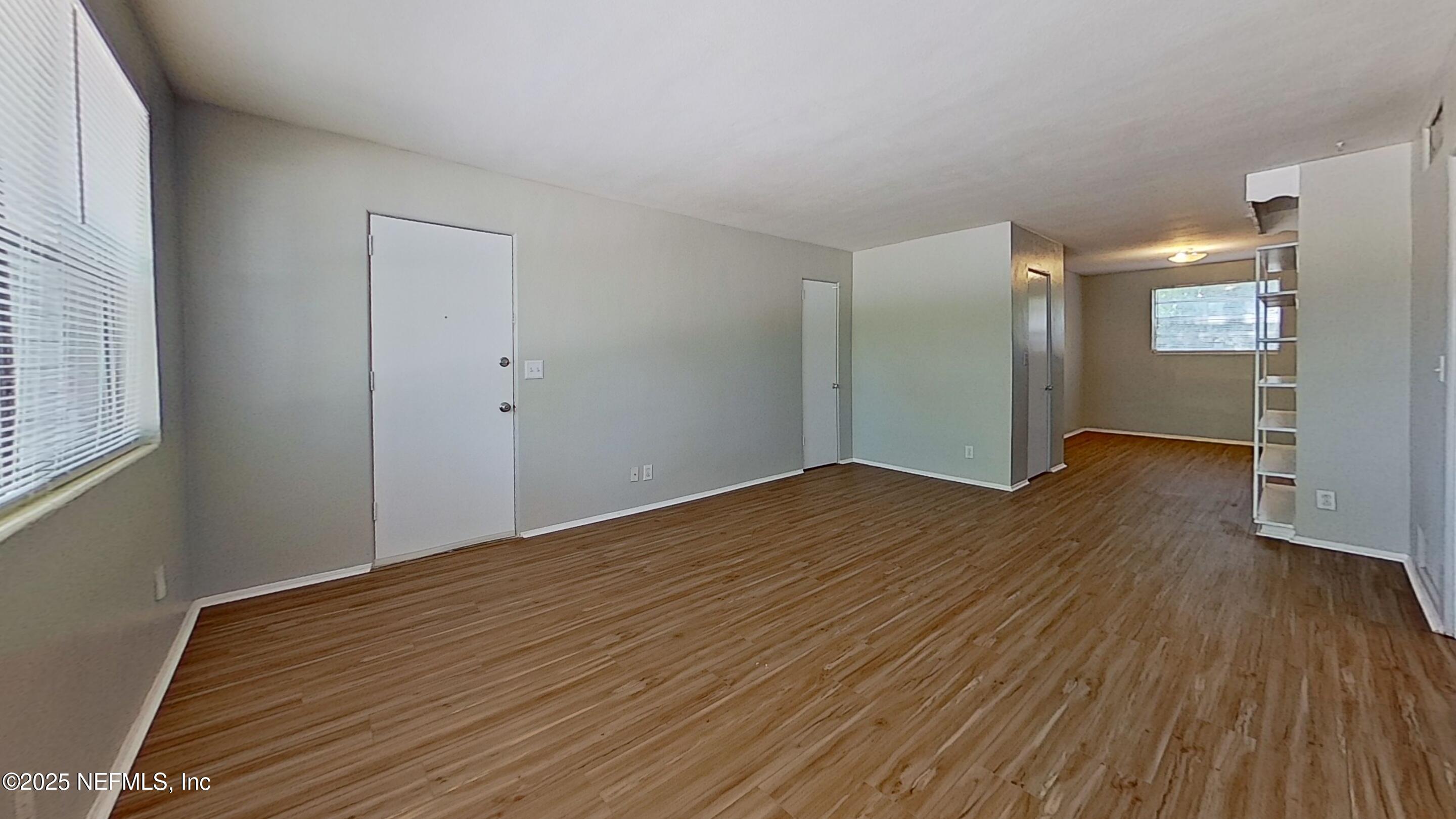 a view of empty room with wooden floor