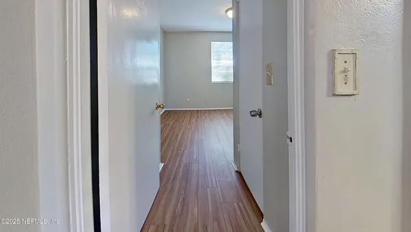 a view of a hallway with wooden floor