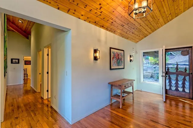 a bedroom with a large bed and a large window with wooden floor