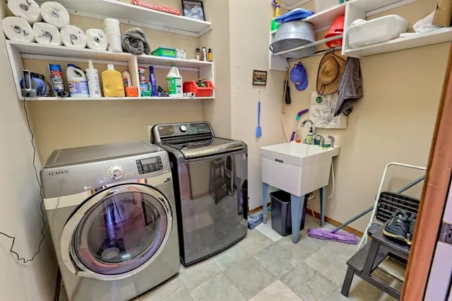 a view of a storage & utility room with clothes shoes and a large window