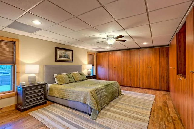 a view of empty room with wooden floor and fan