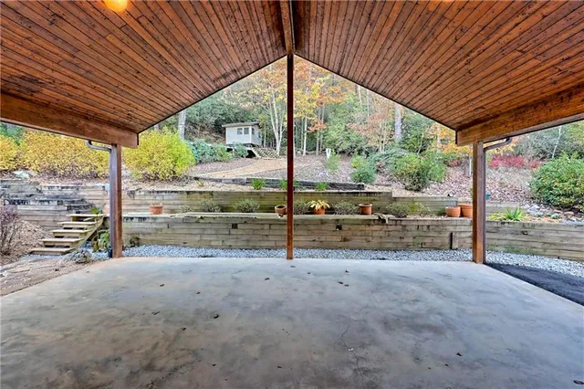a living room with furniture a rug and a floor to ceiling window