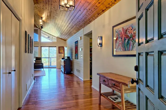 a view of a hallway with wooden floor and furniture
