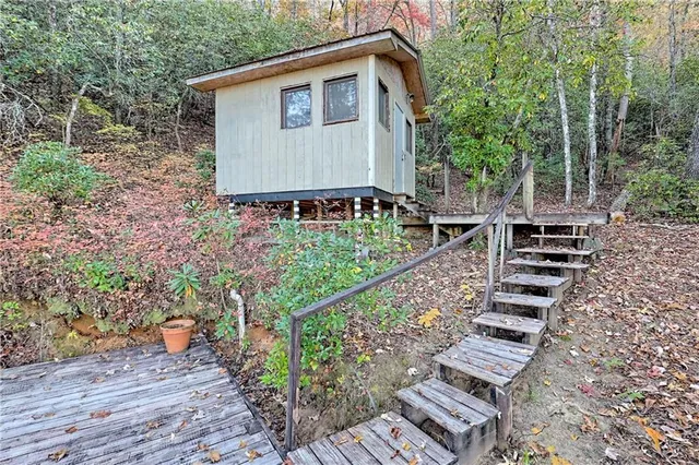 a kitchen with stainless steel appliances granite countertop a refrigerator a sink dishwasher a dining table and chairs with wooden floor