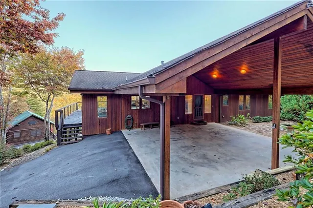 a front view of a house with a yard and mountain view in back