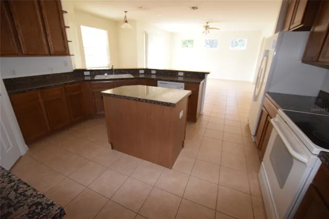 a kitchen with a sink a stove top oven and cabinets