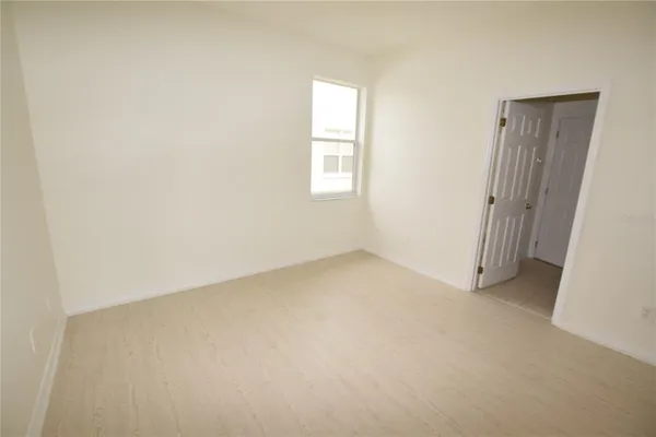 an empty room with windows and closet