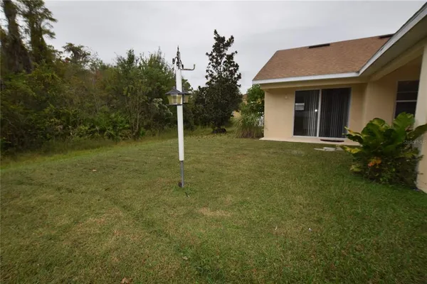 a backyard of a house with plants and large trees