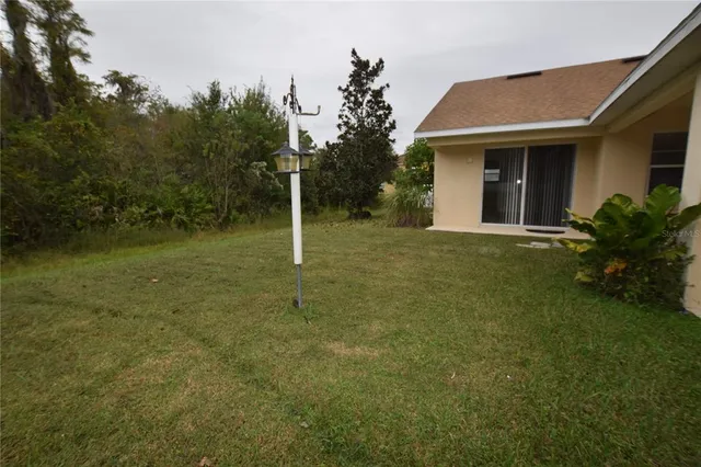 a backyard of a house with plants and large trees