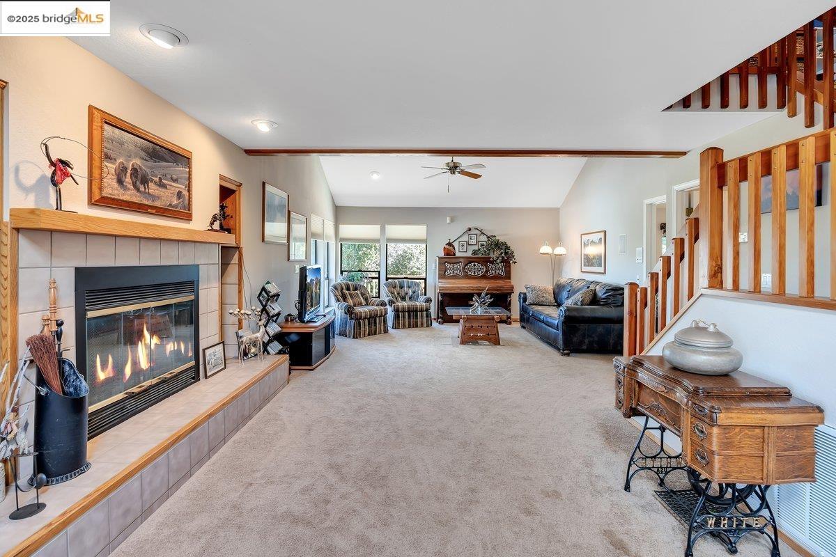 13700 Clements Road Groveland, CA 95321 - Photo 41 of 93 Living room with a tiled fireplace, carpet, lofted ceiling, and ceiling fan