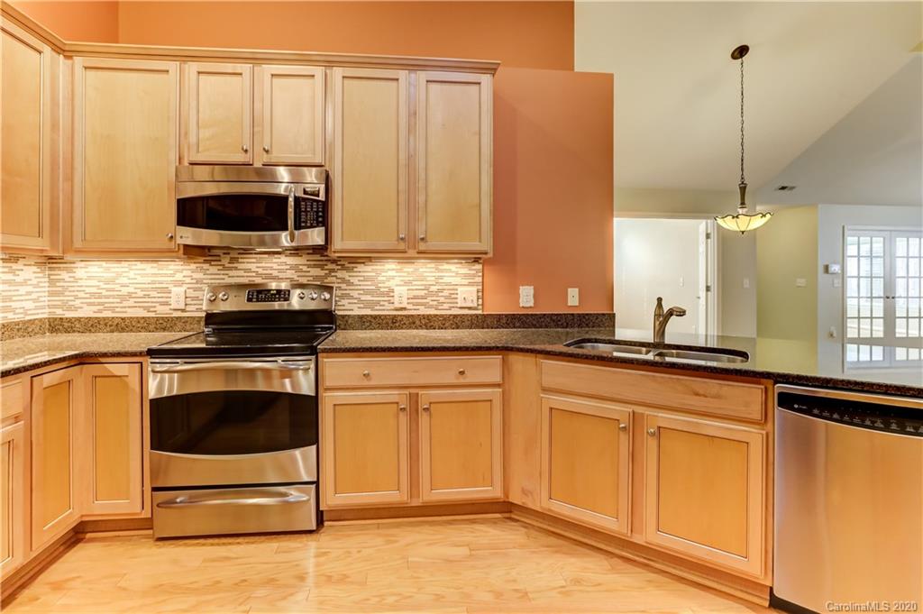 830 Ledgestone Court Tega Cay, SC 29708 - Photo 16 of 47 a kitchen with stainless steel appliances granite countertop a stove a sink and a microwave