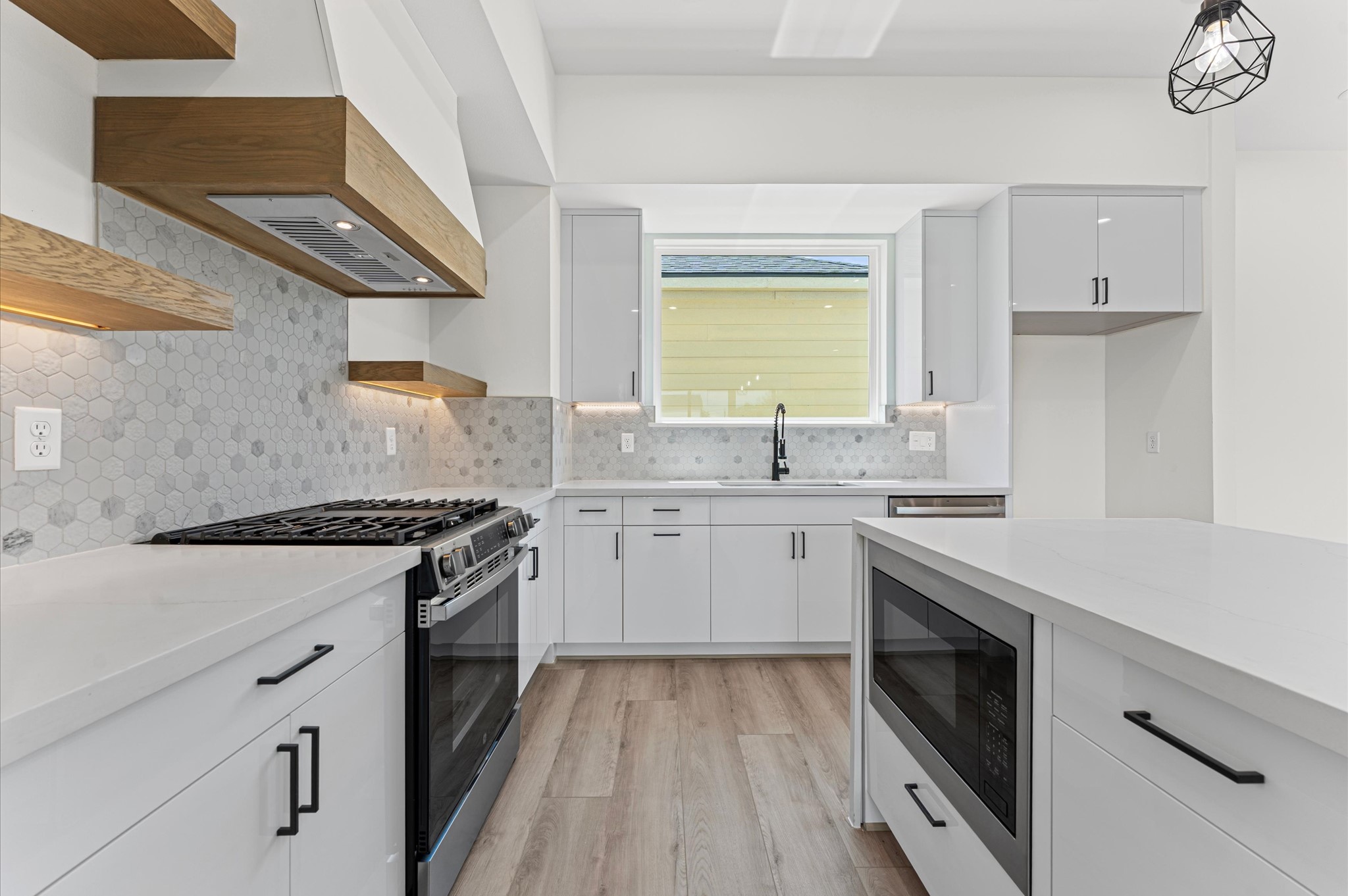 4104 Alice Street Houston, TX 77021 - Photo 15 of 28 a kitchen with a stove white cabinetry and sink
