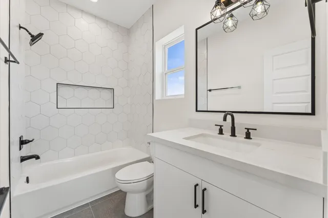 a bathroom with a bathtub sink and mirror