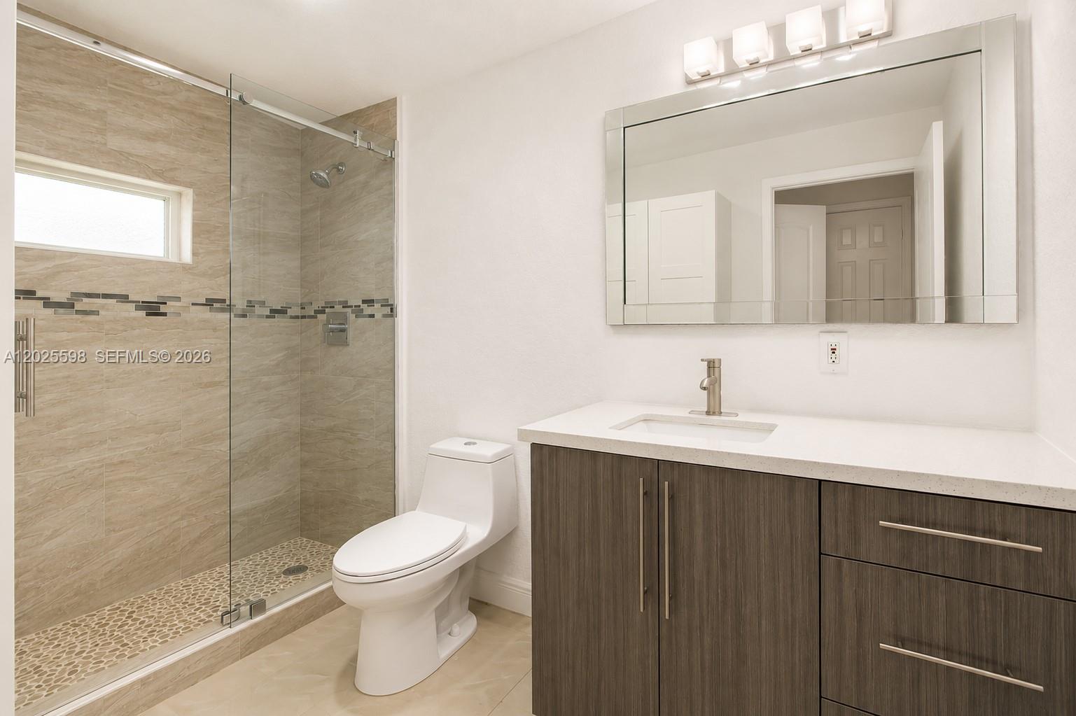 9421 Southwest 150th Street Miami, FL 33176 - Photo 21 of 31 a bathroom with a toilet a sink a mirror and a shower