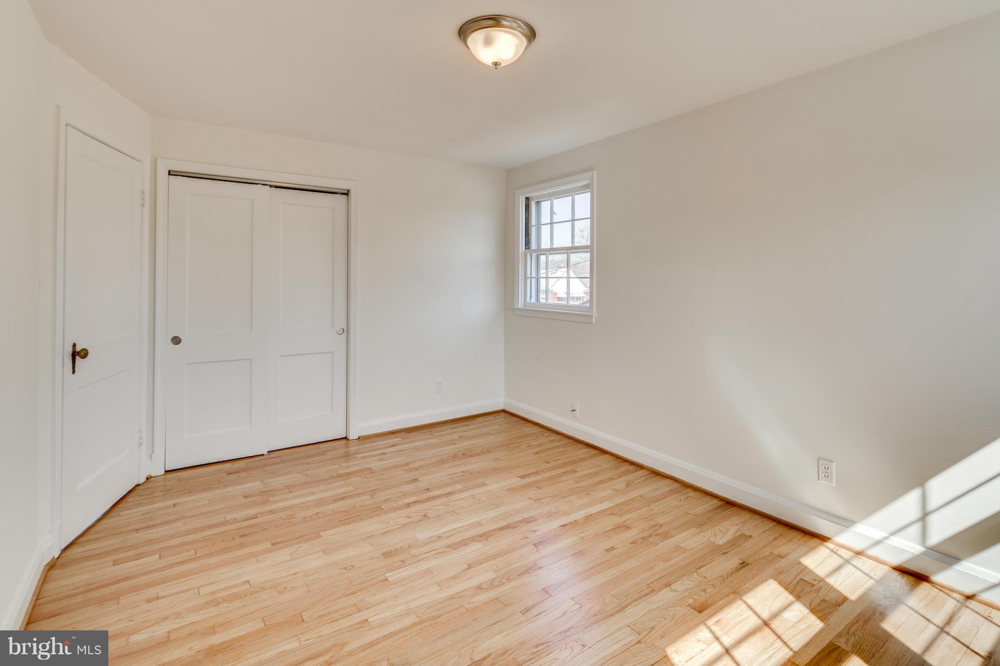 1512 Langford Road Baltimore, MD 21207 - Photo 20 of 30 a view of an empty room with wooden floor and a window