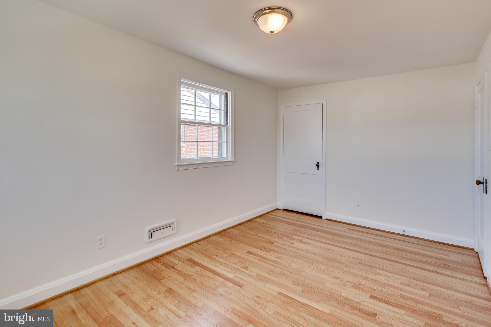 1512 Langford Road Baltimore, MD 21207 - Photo 22 of 30 a view of an empty room with wooden floor and a window