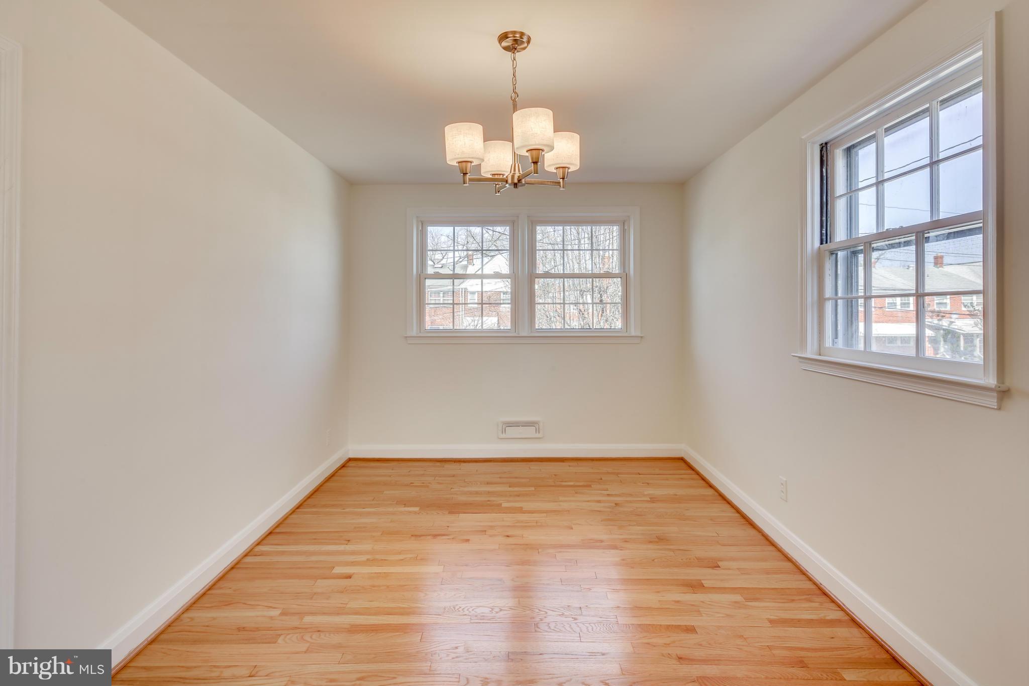 1512 Langford Road Baltimore, MD 21207 - Photo 6 of 30 a view of an empty room with wooden floor and windows
