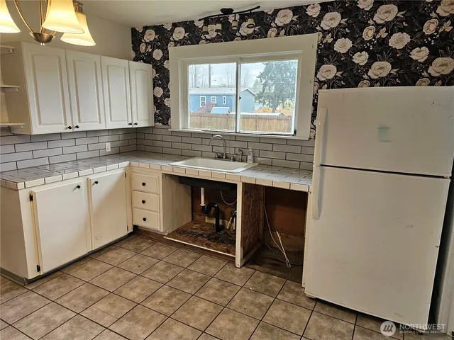 a kitchen with a refrigerator and a sink