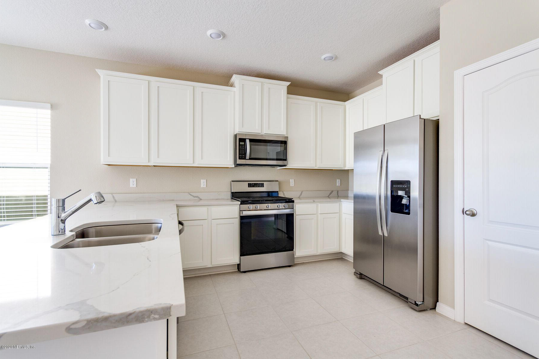 98 Tree Frog Way St. Augustine, FL 32095 - Photo 4 of 19 a kitchen with a refrigerator sink and microwave