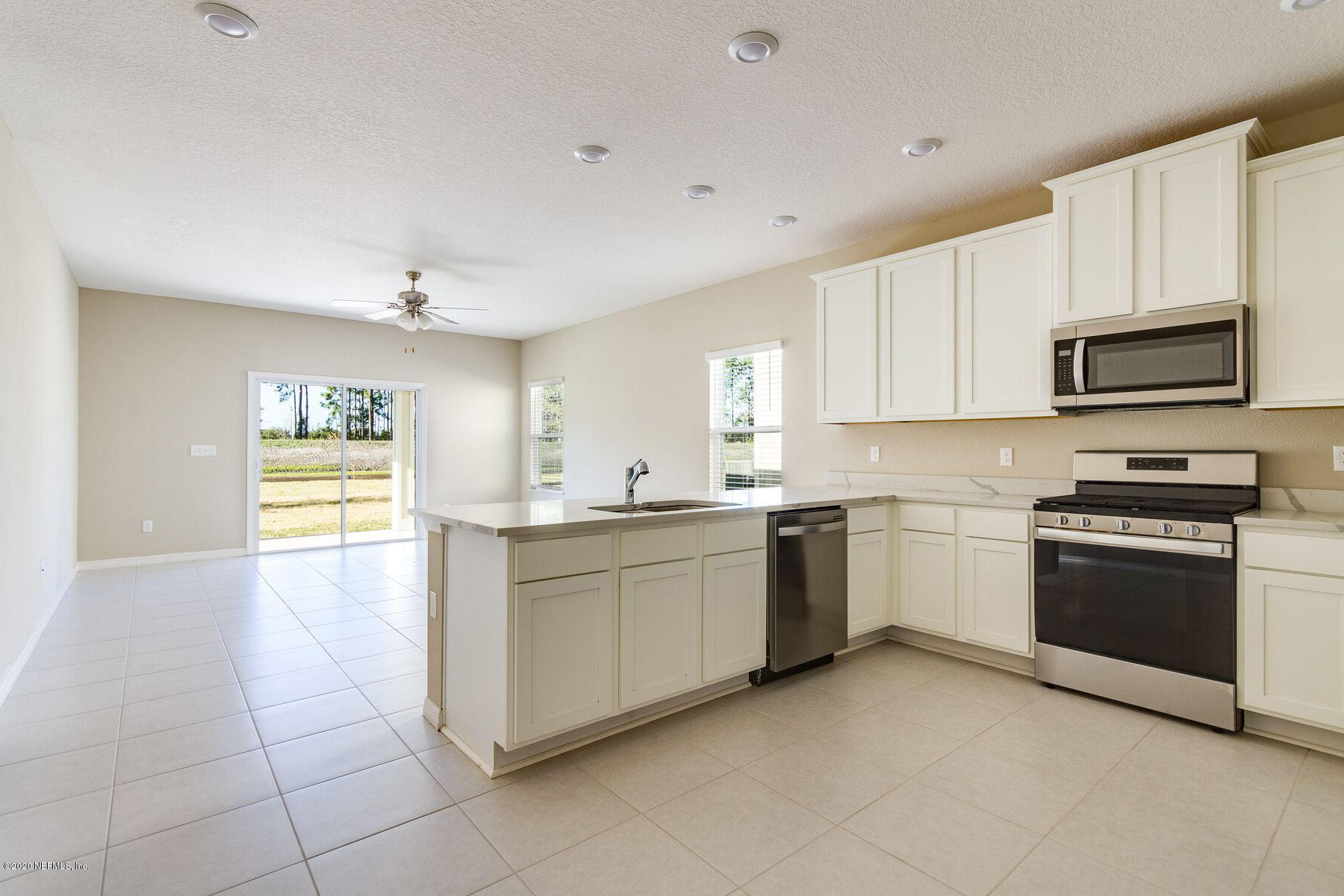 98 Tree Frog Way St. Augustine, FL 32095 - Photo 5 of 19 a kitchen with a stove top oven sink and cabinets