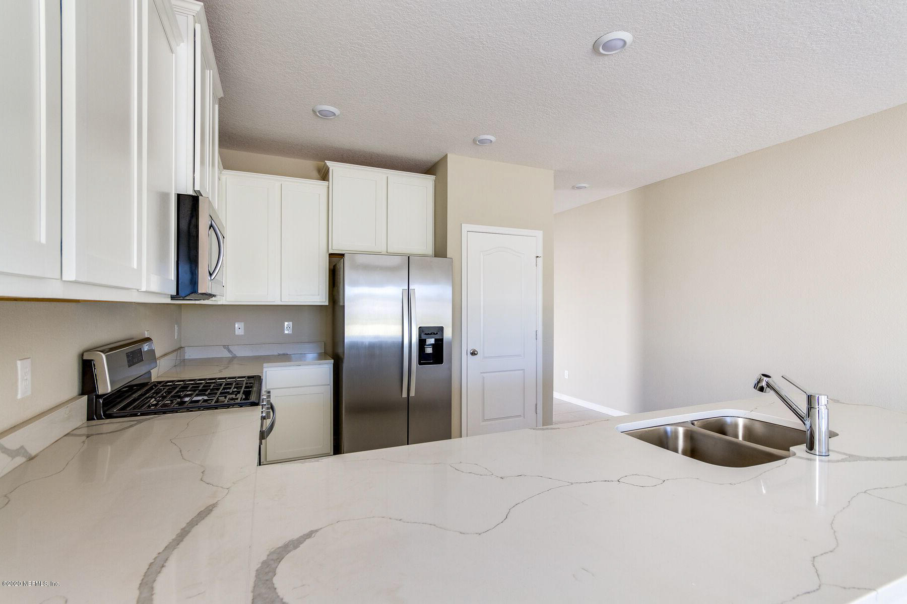 98 Tree Frog Way St. Augustine, FL 32095 - Photo 6 of 19 a kitchen with a refrigerator and white cabinets