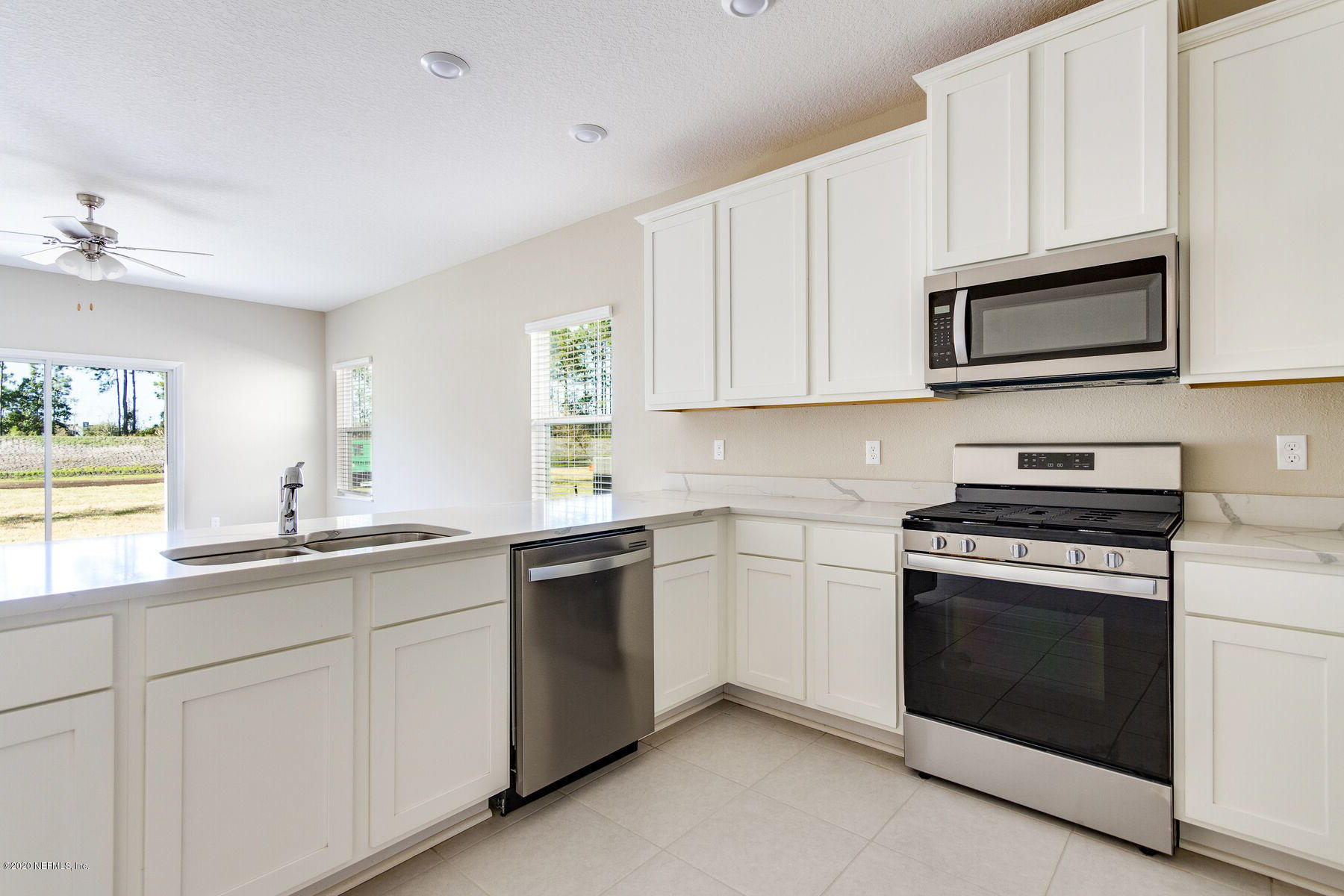 98 Tree Frog Way St. Augustine, FL 32095 - Photo 7 of 19 a kitchen with cabinets stainless steel appliances a sink and a window