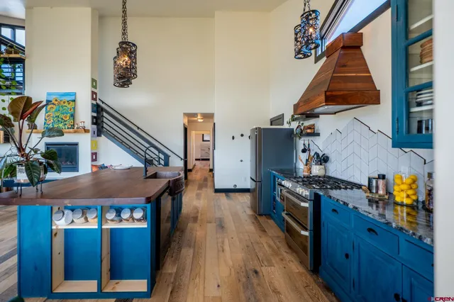 a kitchen with sink stove and wooden floor