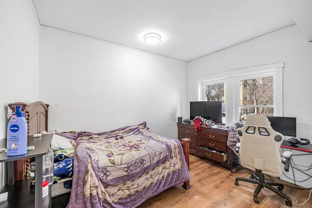 a view of a hallway with wooden floor and a bathroom
