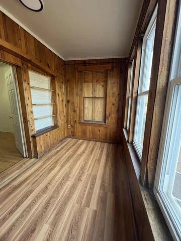 an empty room with wooden floor and a ceiling fan