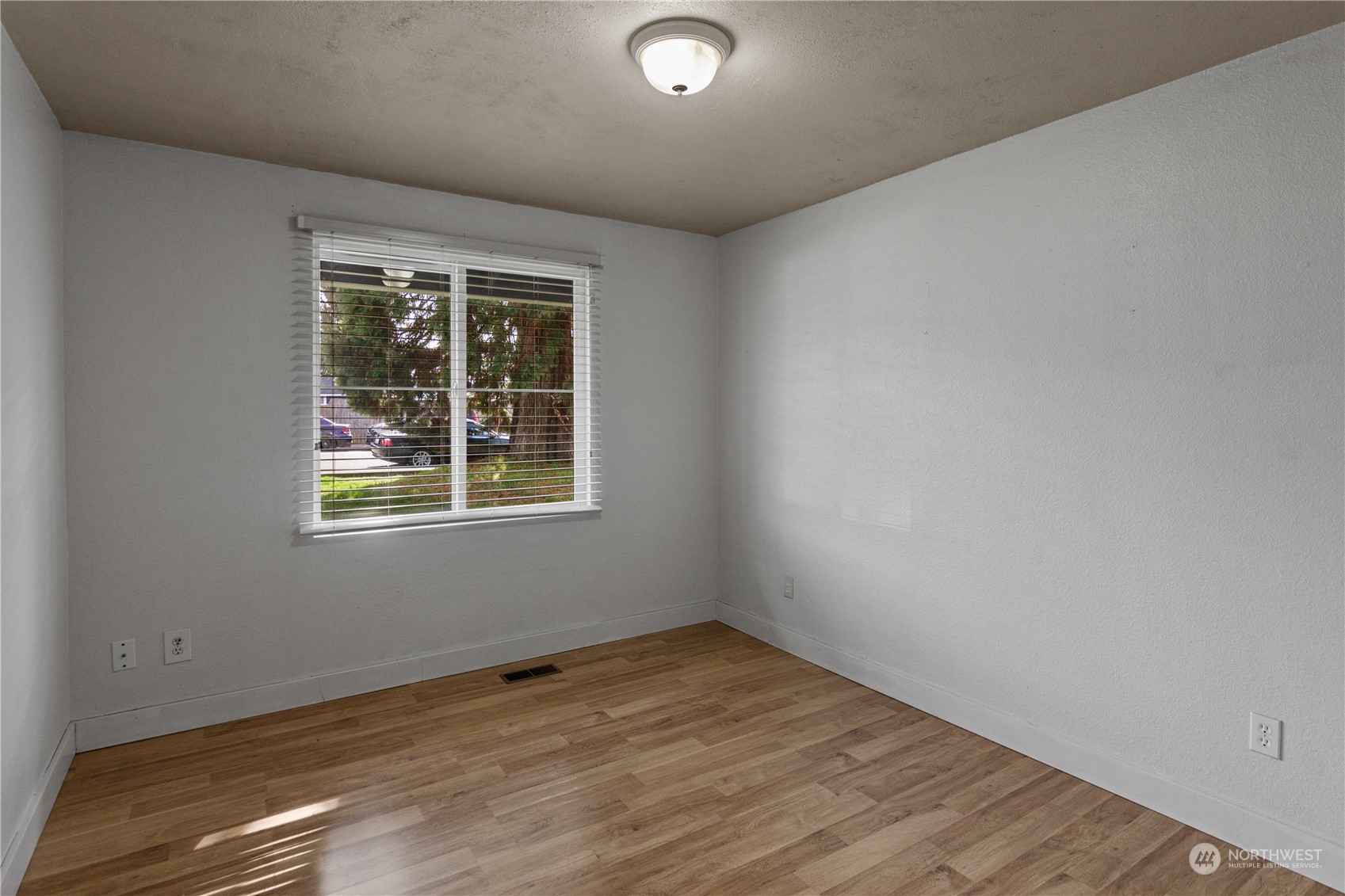 4706 Northeast 18th Street Renton, WA 98059 - Photo 17 of 26 an empty room with wooden floor and windows