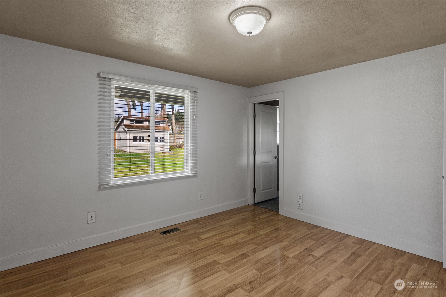 4706 Northeast 18th Street Renton, WA 98059 - Photo 20 of 26 an empty room with wooden floor and windows