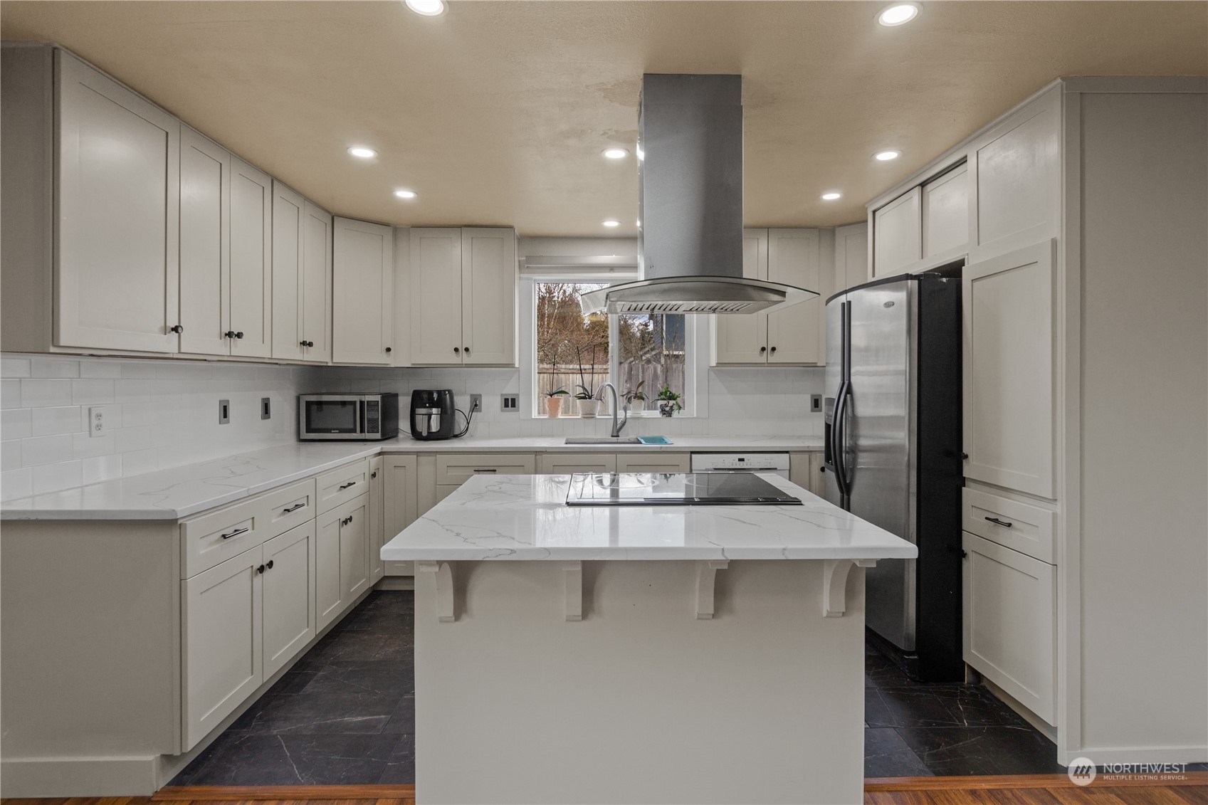 4706 Northeast 18th Street Renton, WA 98059 - Photo 9 of 26 a kitchen with kitchen island a counter top space a sink stainless steel appliances and cabinets