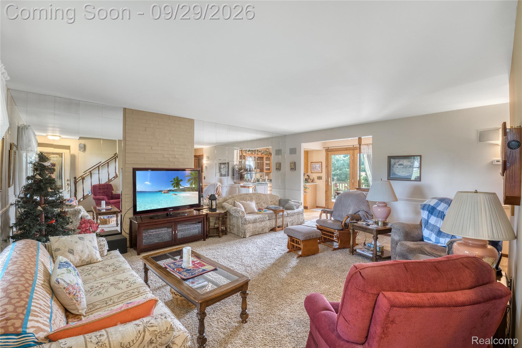 6411 Farrand Road Clio, MI 48420 - Photo 10 of 33 Carpeted living area featuring a central brick-faced column, a built-in media console, and a mirrored wall accent