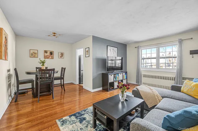 a living room with furniture wooden floor and a window