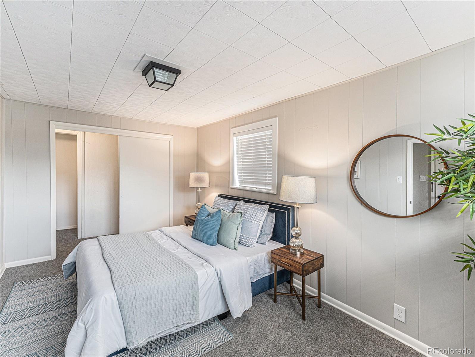 3895 Pierce Street Wheat Ridge, CO 80033 - Photo 12 of 33 a bedroom with a bed and a chandelier