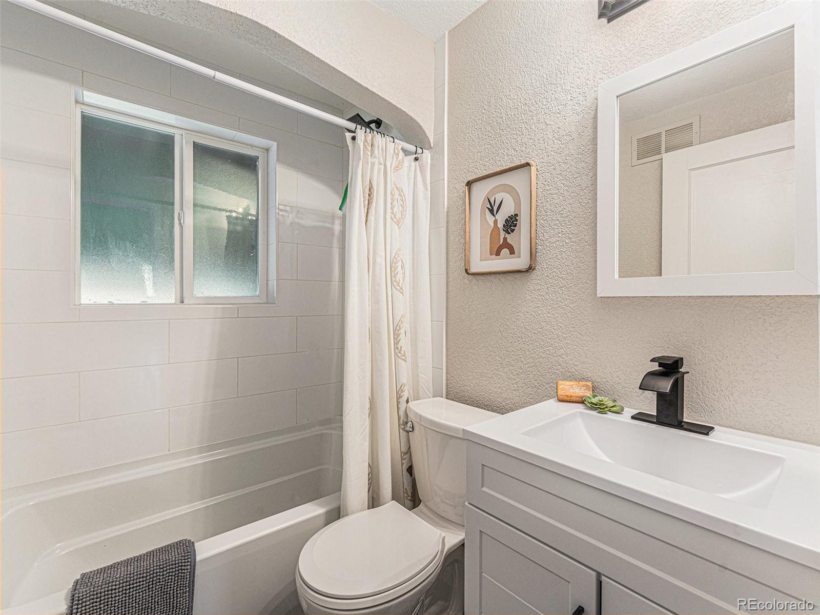 3895 Pierce Street Wheat Ridge, CO 80033 - Photo 13 of 33 a bathroom with a sink a toilet and shower