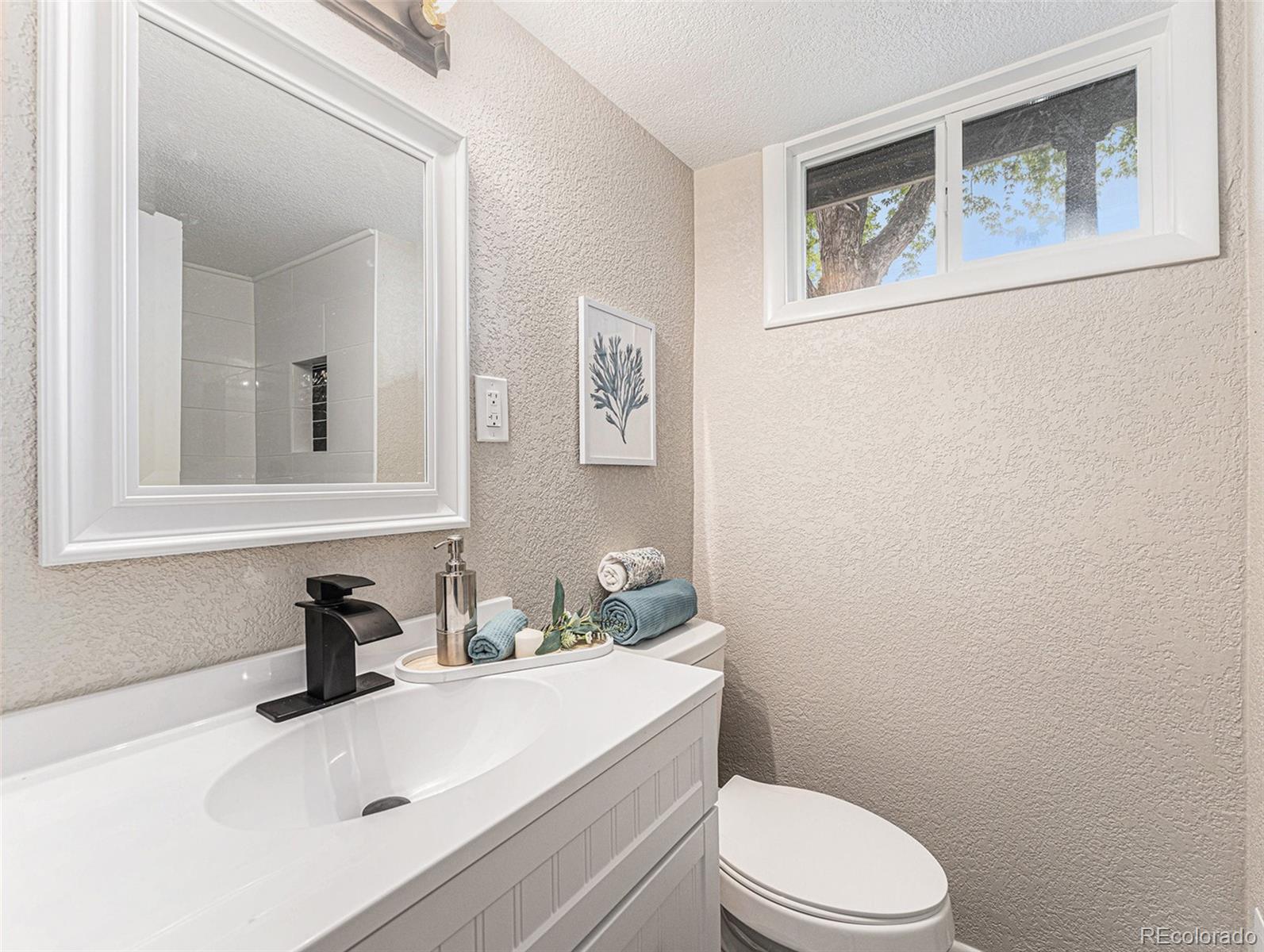 3895 Pierce Street Wheat Ridge, CO 80033 - Photo 18 of 33 a bathroom with a sink mirror vanity and toilet